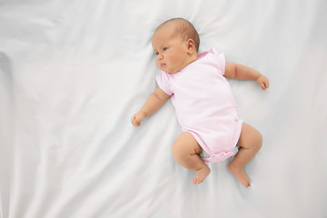 Cute baby on bed, top view