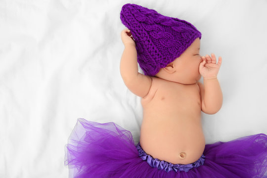 Cute Baby In Purple Skirt Sleeping On Bed