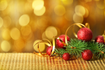 Composition of baubles, ribbon and coniferous branch on blurred background, close up