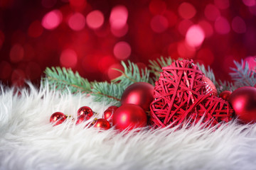 Close up view of Christmas decor on white fur against defocused lights