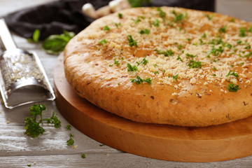 Plate with tasty garlic bread on wooden table