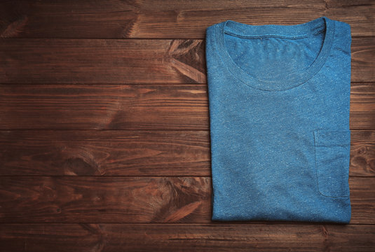 Blank blue t-shirt on wooden background