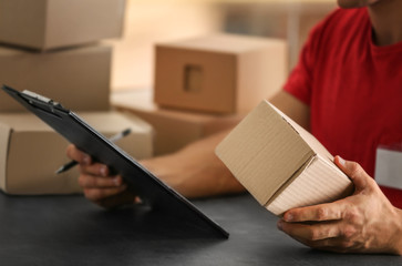 Courier holding carton box and delivery receipt