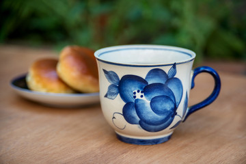 Tea set. Porcelain vintage cup and  teapot with cakes outdoors.