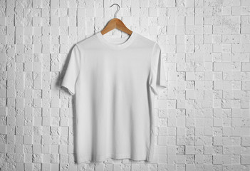 Blank white t-shirt against light textured background