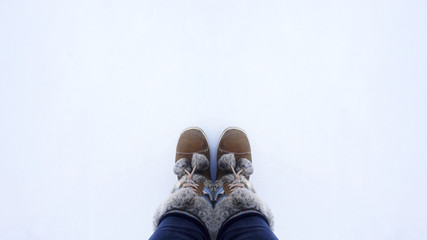 woman boots standing in the snow, top view with copy space
