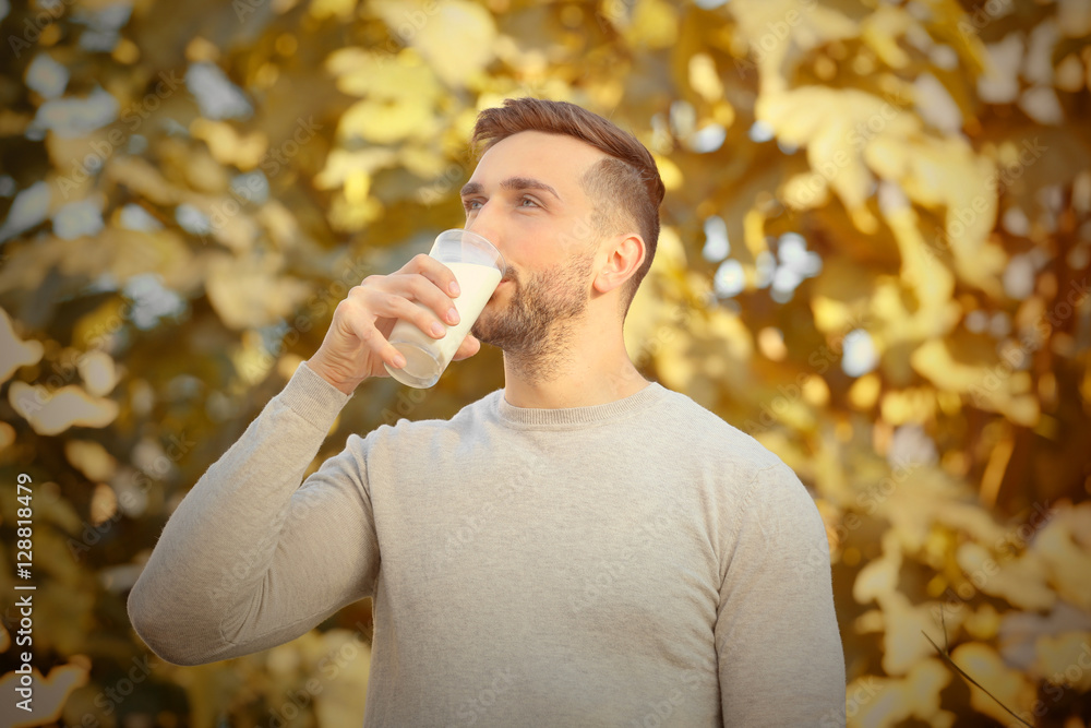 Wall mural Young man with glass of fresh milk outdoor