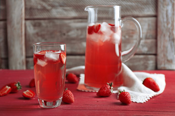 Glass of refreshing strawberry drink on table