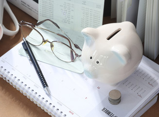 Pig piggy bank, coins, bank book, glasses. The concept of saving money