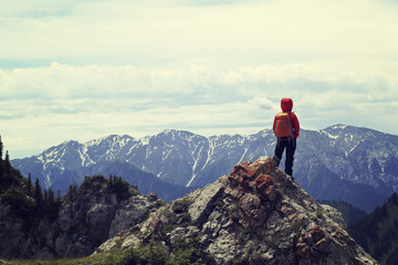 Fototapeta premium successful woman backpacker enjoy the view on mountain peak