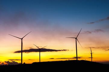 Fototapeta na wymiar Wind turbine power generator at cloudy sky and sunset, alternative energy resources