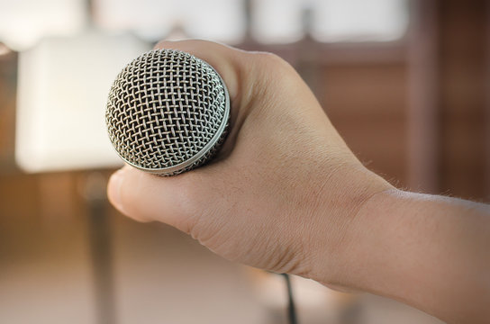 Close-up of handle microphone in concert hall or conference room