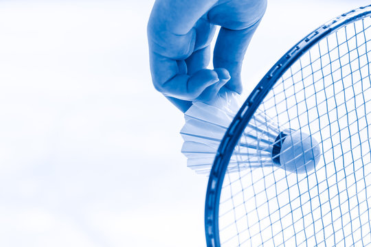 Badminton sport start playing, closeup hand serve badminton shuttlecock in badminton court.