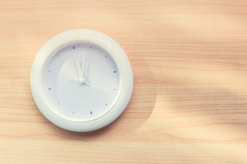 Fototapeta na wymiar simple white circle clock on wood wall background.