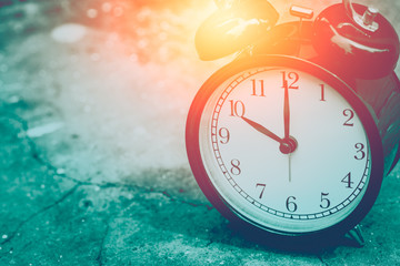 closeup vintage clock selective focus at number 10 o'clock with sun light vintage color tone for postcard.