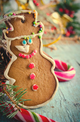 Christmas, New Year Composition with Gingerbread Man, Tangerines, Fir Tree, Cinnamon and Candy Canes. Shiny Holiday Decoration on Blue Wooden Background