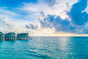 Obraz premium Beautiful water villas in tropical Maldives island at the sunset