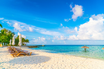 Beach chairs with umbrella at Maldives island, white sandy beach