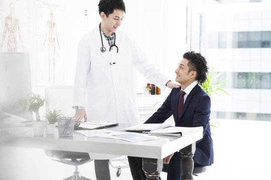 A young businessman is encouraged by a doctor