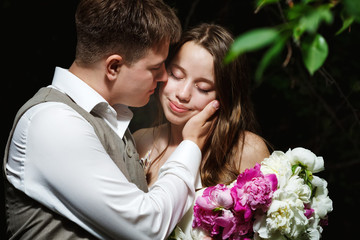 Loving wedding couple kissing in the park