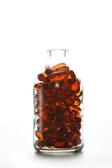 Bottle with gelatin capsules on white background