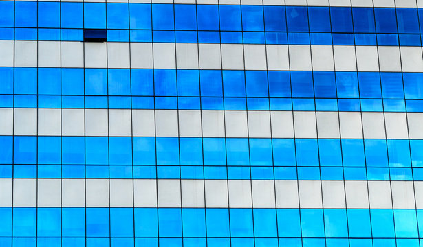 reflected in windows of modern office building