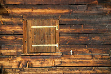 closed window shutter on a sunburned cabin