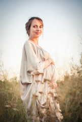 Fototapeta na wymiar Portrait of a pregnant woman in the sunset light