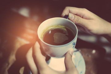 Female hands holding cup of coffee.