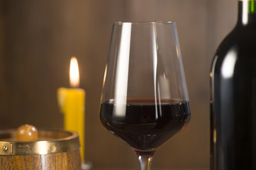Pouring red wine into wineglass from green bottle