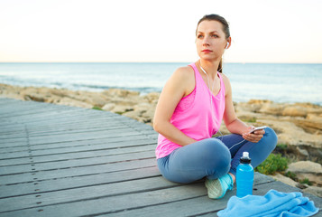Fototapeta na wymiar Athletic woman resting after running at the morning training by