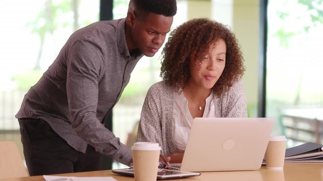 Young happy co-workers using a computer