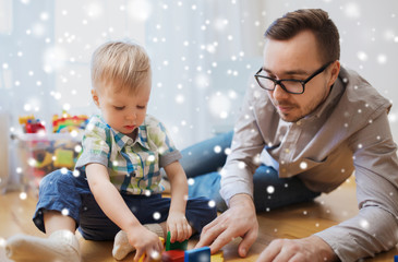Naklejka premium father and son playing with toy blocks at home