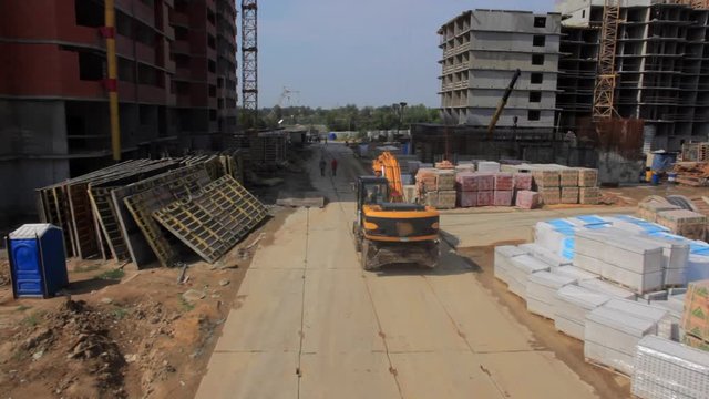 The development of cities and construction of new areas. The camera moves from the truck to the construction site