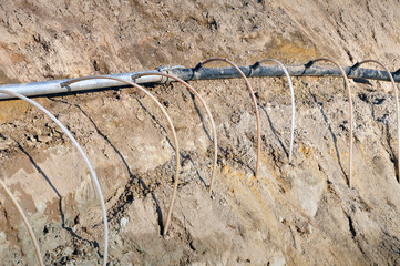 The process of lowering the groundwater level. Metal pipe with thin tubes directed to land on the...