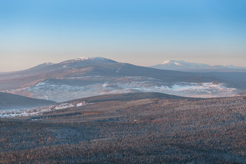 Distant view of the Ural town with winter mountains, Russia