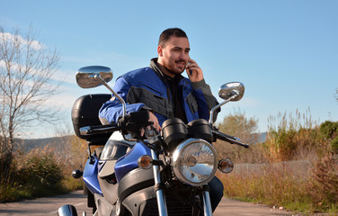 Biker talking by phone with his smarth phone