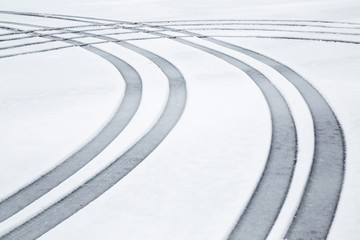 Car tire imprint in the wet, soft snow on the asphalt in winter day. Slippery road. Background.