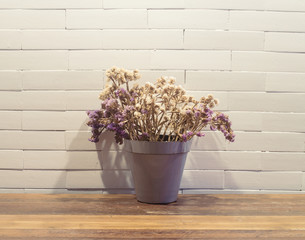 dried flowers in flowerpot on wooden table ( Vintage tone color )