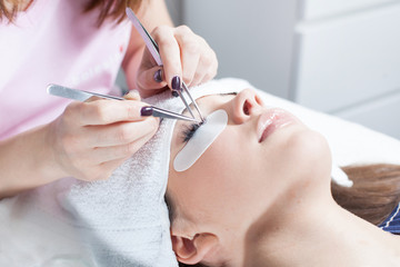beautician making artificial lashes. eyelash extension procedure  - obrazy, fototapety, plakaty