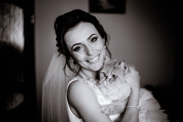 gentle and happy bride holding her cute and fluffy cat