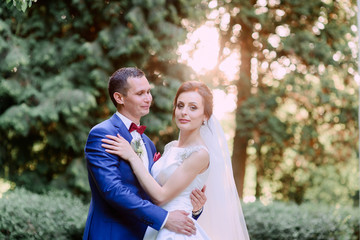 Fototapeta premium beautiful and young groom and bride standing together outdoors