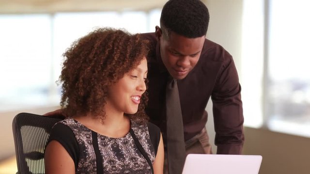 Two black millennials working in a highrise office