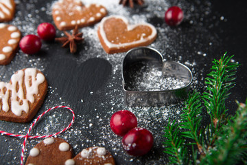 Christmas gingerbread cookies with festive decoration on black stone background, selective focus. Holiday concept