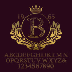 Golden ornate letters and numbers with initial monogram in coat of arms form. Decorative patterned font for logo design. Isolated english vintage alphabet, figures.