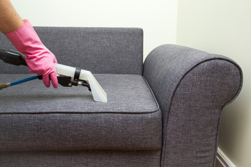Sofa chemical cleaning with professionally extraction method. Upholstered furniture professionally chemical cleaning in hotel and house. Early spring cleaning or regular clean up.