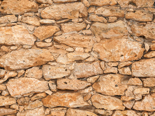 Old stone wall close up in sunny day