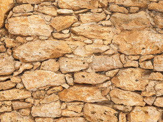 Old stone wall close up in sunny day