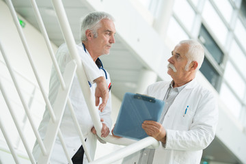 Fototapeta premium Senior workers in discussion on staircase