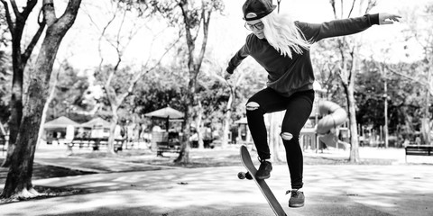 Young Woman Jumping Olly Skateboard Concept